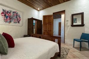 una camera da letto con un letto e una sedia blu di Toucan Villa Family home w Private Pool Garden AC a Quepos Altre 34 foto