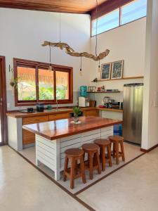 una cucina con un'ampia isola con ripiani in legno di Casa Janela da Lua a Icaraí