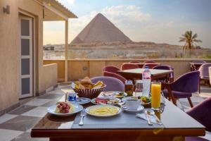a table with food and a view of the pyramids at AL Farida Boutique Pyramids in Cairo