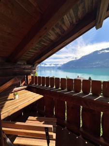 a table and chairs on a deck with a view of the ocean at NEU! Seepanorama, am See 15 min von Interlaken in Oberried +24 photos
