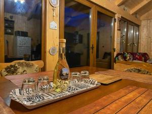 a bottle and glasses on a tray on a table at La Sava lui Traian in Gîrda de Sus +17 photos