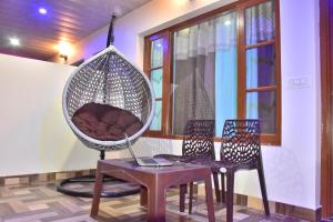 a room with a chair and a swing with a laptop at Sunshine Home Kasauli Hills in Kasauli