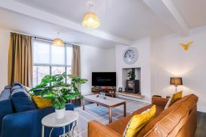 a living room with a couch and a table at Stunning 3BR Townhouse, Terrace, Games, Free Parking in Manchester +31 photos