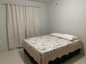 un piccolo letto in una stanza con una finestra di Casa Temporada Prado-BA a Prado