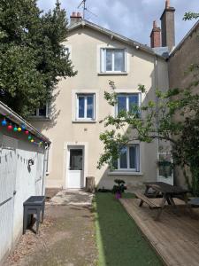 a house with a picnic table in front of it at Étape du faubourg I Orléans I Proche Gare in Orléans