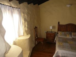 グラナディージャ・デ・アボナにあるCasa Pepaのベッドルーム1室(ベッド1台、椅子、窓付)