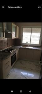 a kitchen with a sink and a stove top oven at Le bon coin in Ariana