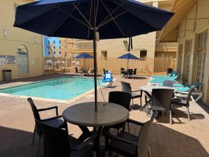a table with an umbrella in front of a pool at Days Inn by Wyndham Georgetown in Georgetown