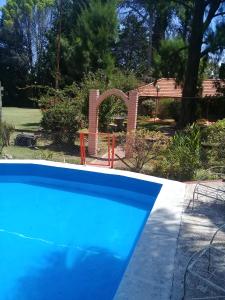 una piscina azul frente a un patio en Complejo LOS PINOS, en La Porteña