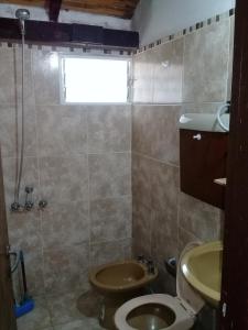 un baño con inodoro y ducha en Complejo LOS PINOS, en La Porteña
