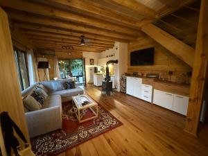 a living room with a couch and a table at Domek pod świerkiem in Tereszpol Zaorenda