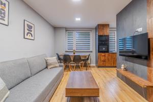 a living room with a couch and a table at Apartament Lubliniec Centrum, PW Invest Home in Lubliniec +22 photos