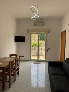 a living room with a table and a couch at Stanze Matrimoniali Nicchia della Ninfa in Castelvetrano Selinunte