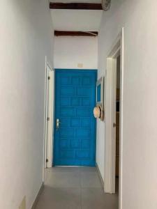 ein Flur mit einer blauen Tür in einem Zimmer in der Unterkunft Relax Pasito Blanco in Pasito Blanco