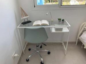 ein weißer Schreibtisch mit einem Stuhl und einem Buch in der Unterkunft Relax Pasito Blanco in Pasito Blanco