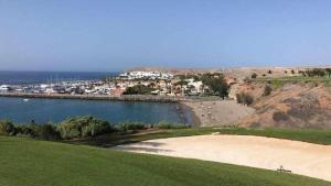 einen Golfplatz mit Strand und einer Wasserfläche in der Unterkunft Relax Pasito Blanco in Pasito Blanco + 28 Fotos