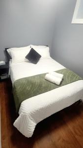 a large white bed with two pillows on it at Quiant 2 Bedroom Suite in Vancouver