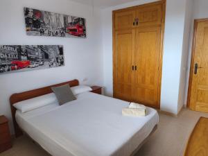 Un dormitorio con una cama y una puerta de madera. en Almerimar Sea, Golf and Views, en Almerimar