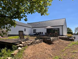 a white house with a picnic table and chairs at Maison Lesve in Profondeville