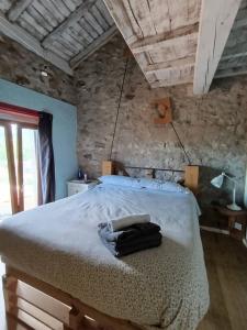 a bedroom with a large bed with a stone wall at Habitación Doble Cian Baño Privado Cartes in Cartes +12 photos