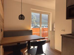 a kitchen with a wooden table and a window at Das Anja Alt Filzmoos in Filzmoos
