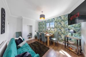 a living room with a blue couch and a table at Thorold House Charming house for long stays in Chatham +20 photos