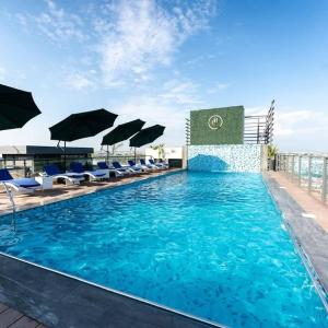 a swimming pool with chairs and umbrellas at Kazani Heights Luxurious apartments in Islamabad