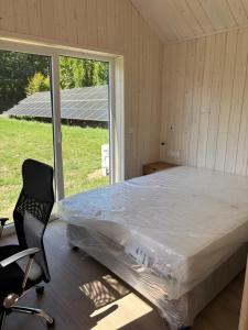 a bedroom with a bed and a chair and a window at Domki nad Krzyworzeką in Dobczyce