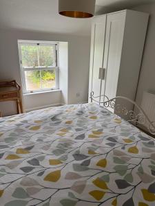 ein großes Bett in einem Zimmer mit Fenster in der Unterkunft Buddleia Cottage Trewoon, St Austell in St Austell