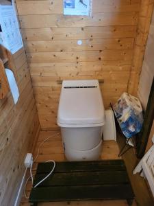 un piccolo bagno con servizi igienici in una parete di legno di Koselig og usjenert hytte med fantastisk utsikt og solforhold a Gjerset