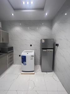 a white kitchen with a refrigerator and a counter at Summo bilding in Jeddah