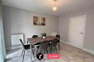 a dining room with a wooden table and chairs at Spacious 4 Bedroom House for 8 Guests Ideal for Families and Contractors, WIFI and Free Parking in Aldershot +14 photos