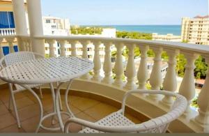 a table and chair on a balcony with the ocean at Two-Bedroom Deluxe Apartment with Ocean View in Mombasa