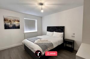 a bedroom with a bed with a ceiling at Spacious 4 Bedroom House for 8 Guests Ideal for Families and Contractors, WIFI and Free Parking in Aldershot