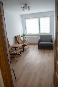 a living room with a chair and a couch at Apartament przy Wolnej in Sanok
