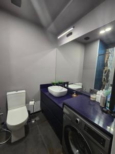 a bathroom with a toilet and a sink and a washing machine at Green House Mindeli in Tbilisi City +10 photos