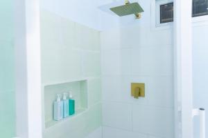 a white bathroom with a shower with white fixtures at Cozy apartment monica in San Pedro Sula +33 photos