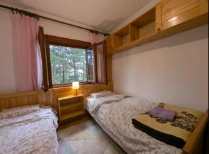 a bedroom with two beds and a window at Vikendica Vidik in Divčibare