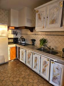 a kitchen with white cabinets and a sink at Vauville Sunset in Vauville