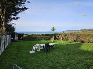 a picnic table and two chairs in a yard at Vauville Sunset in Vauville
