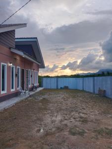 ein Haus mit einem Zaun vor einem Hof in der Unterkunft Homestay Salsabila Langkawi in Kampung Padang Masirat