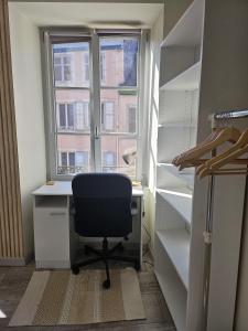 モンベリアルにあるLuxury apartment city center Montbeliardの窓のある客室で、デスクと椅子が備わります。