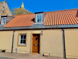 a house with a orange roof and a door at May Cottage in Anstruther
