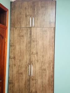 a wooden cabinet in a corner of a room at He Is My Peace in Accra