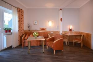 a living room with chairs and a table and a couch at Erlkönig Gästeappartements in Bad Füssing