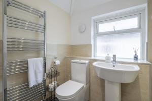 a bathroom with a toilet and a sink and a window at 4 BDR I sleeps 8 I Wi-FI I Free Parking I Central in CBG +39 photos