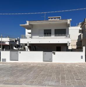 a white house with two doors in front of it at Villa PO in Torre Santa Sabina
