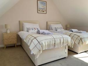 two beds sitting next to each other in a bedroom at May Cottage in Anstruther