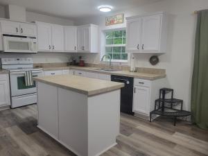 a kitchen with white cabinets and a counter top at Northern Nirvana in Kalkaska