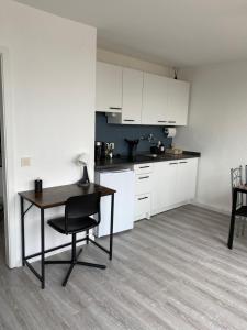 a kitchen with a desk and a table with a chair at City Appartment in Essen